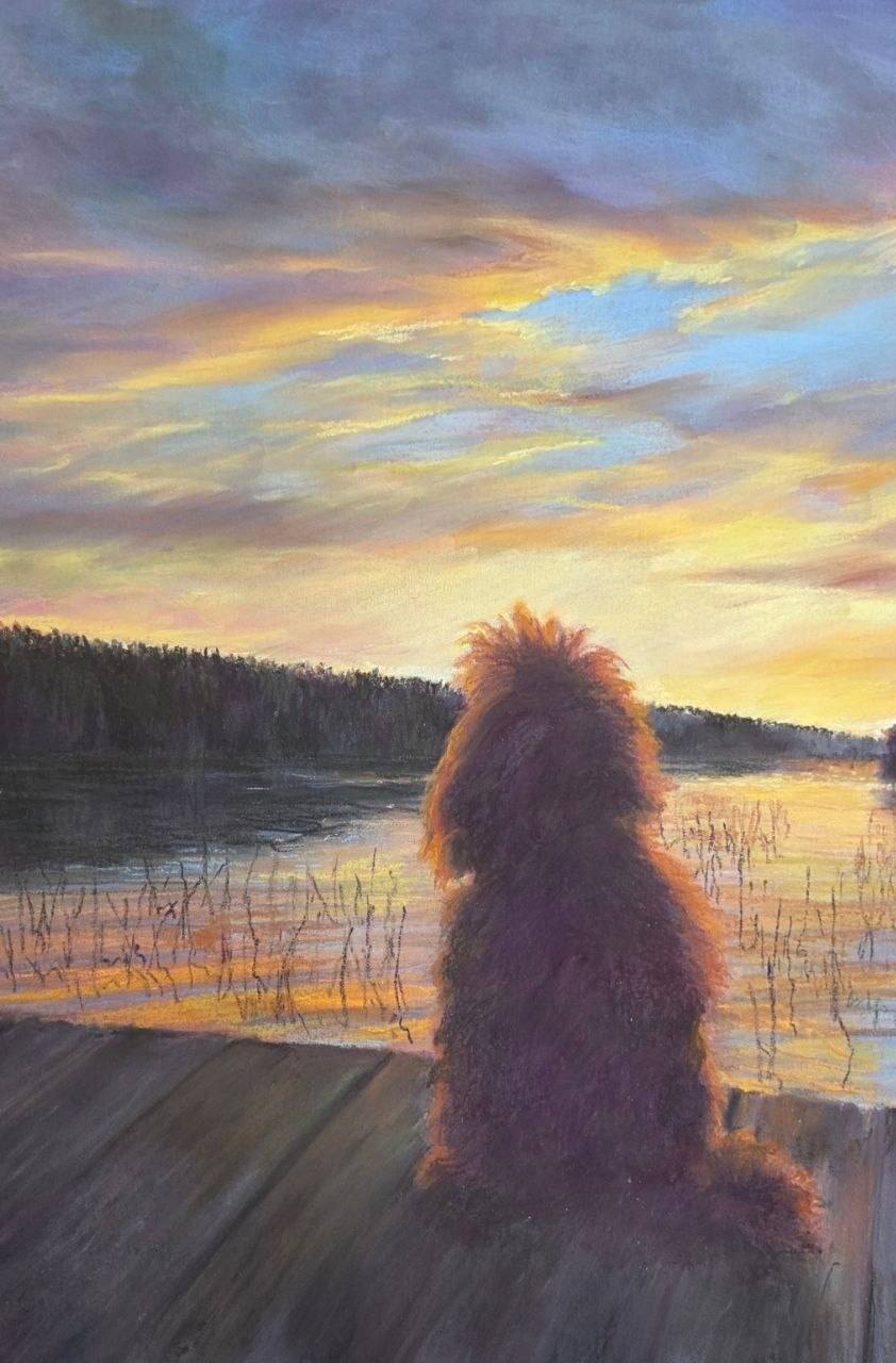 Pastel landscape of a fluffy dog sitting with its back to the viewer on a wooden deck by a lake, beneath a golden sky above a dark forest.